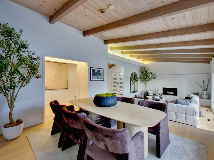 Dining area under a beamed ceiling, open to the living room